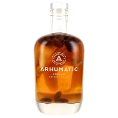Arhumatic Criollo Banane Cacao. Klare Flasche mit bernsteinfarbenden Inhalt und Banane und Kakaobohnen mit weißer Arhumatic Aufschrift.